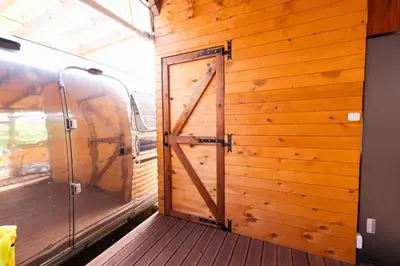 a wooden door in a room with a wooden wall at Luxury Vintage Airstream RV/Caravan Retro Charm Meets Comfort in Kiten