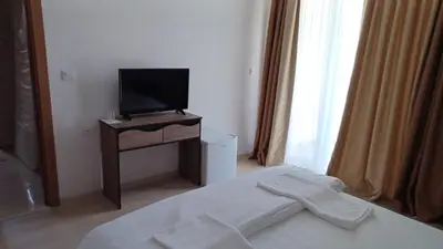 a bedroom with a bed and a television on a table at ARIA in Primorsko