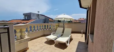 a balcony with two chairs and an umbrella at Luxury Apartments Ekaterina in Chernomorets