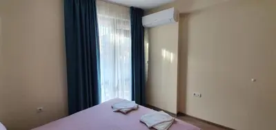 a bedroom with a bed with a window and two towels at Luxury Apartments Ekaterina in Chernomorets