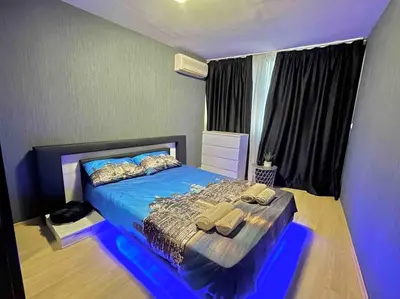 a bedroom with a bed with blue lights on it at By The Sea Apartment in Varna City