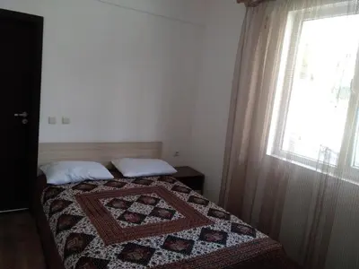 a bedroom with a quilt on a bed with a window at Апартаменты за гости Гаван in Byala