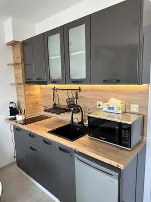 a kitchen with black cabinets and a microwave on a counter at Ив-Бо in Ravda