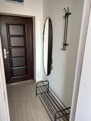 a hallway with a mirror and a chair next to a door at Ив-Бо in Ravda