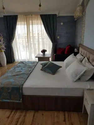 a bedroom with a large bed with pillows on it at Vromos Guest House in Chernomorets
