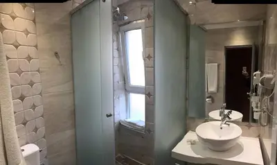 a bathroom with a sink and a shower with a window at Vromos Guest House in Chernomorets