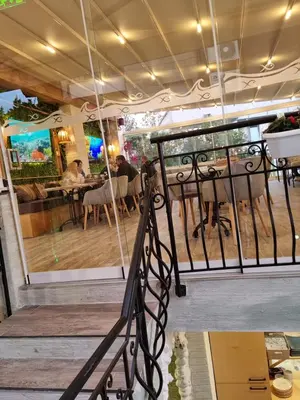 a restaurant with a balcony with people sitting at tables at Vromos Guest House in Chernomorets