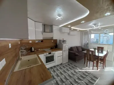 a kitchen and living room with a table and a couch at Apartment Krisiya in Burgas in Burgas City