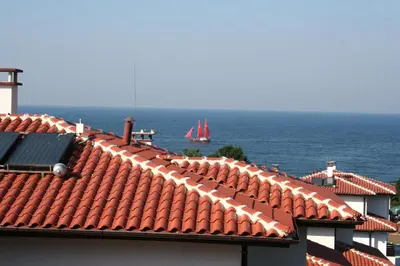a view of the roofs of buildings and the ocean at Kapriz Apartment in Kiten