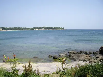 a group of people playing in the water on a beach at Kapriz Apartment in Kiten