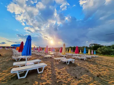 a group of chairs and umbrellas on a beach at Santa Cruz apartment in Burgas City