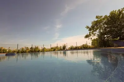 a large pool of water with a fence and trees at Santa Cruz apartment in Burgas City