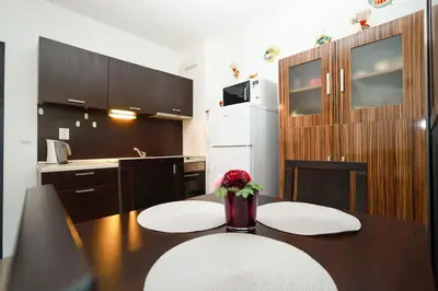 a kitchen with a table with a vase of flowers on it at Santa Cruz apartment in Burgas City
