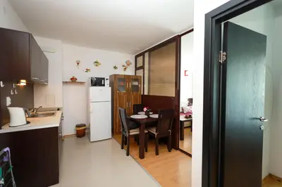 a kitchen and dining room with a table and a refrigerator at Santa Cruz apartment in Burgas City