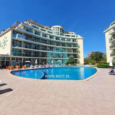 a hotel with a swimming pool in front of a building at Sunny Holiday - Cacao Beach Apartments in Sunny Beach