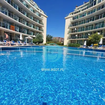 a swimming pool in front of a large building at Sunny Holiday - Cacao Beach Apartments in Sunny Beach