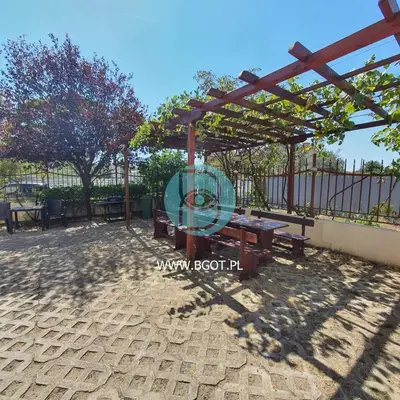 a picnic area with a wooden pergola and benches at Sunny Holiday - Cacao Beach Apartments in Sunny Beach