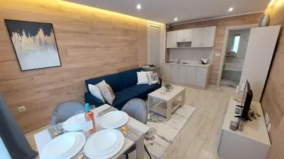 a living room with a blue couch and a table at PARADISO 'В' 201 One Bedroom Apartment in Nesebar