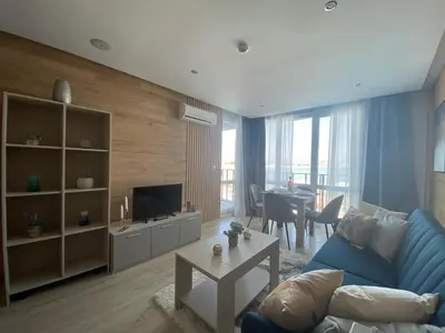 a living room with a blue couch and a table at PARADISO 'В' 201 One Bedroom Apartment in Nesebar
