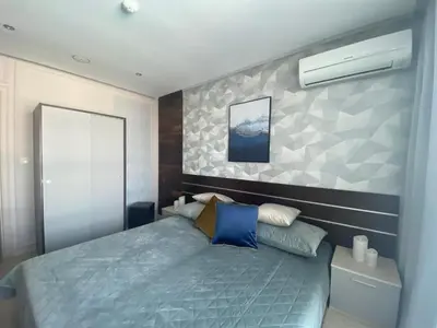 a bedroom with a blue bed and a wall at PARADISO 'В' 201 One Bedroom Apartment in Nesebar
