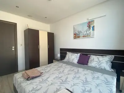 a bedroom with a large bed and a painting on the wall at PARADISO 'В' 207 Two Bedroom Apartment in Nesebar