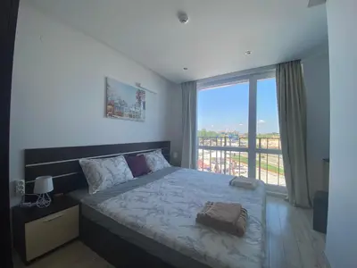 a bedroom with a bed and a large window at PARADISO 'В' 207 Two Bedroom Apartment in Nesebar