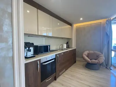 a kitchen with a stove and a chair in it at PARADISO 'В' 607 Large Luxury Apartment in Nesebar