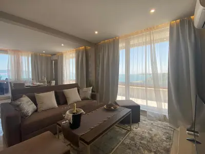 a living room with a couch and a large window at PARADISO 'В' 607 Large Luxury Apartment in Nesebar