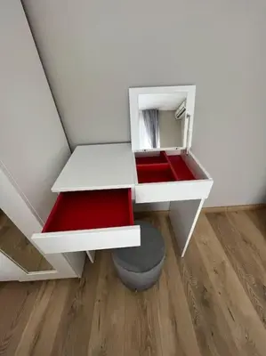 a small white cabinet with a stool in a room at Sea Garden Apartment in Burgas City