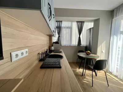 a living room with a table and chairs in a room at Sea Garden Apartment in Burgas City