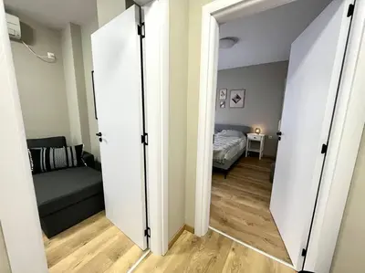 a room with a bed and a room with a mirror at Sea Garden Apartment in Burgas City