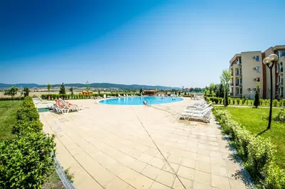 a swimming pool in a resort with lounge chairs at Waterpark Fort Apartments in Sunny Beach