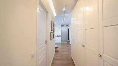 a hallway with white walls and wooden floors at Central DELUXE Apartment in Burgas City