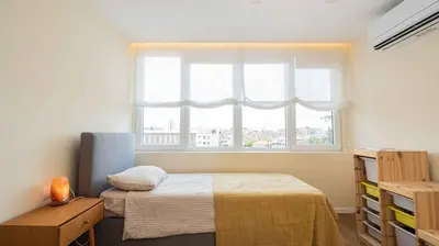 a small bedroom with a bed and a window at Central DELUXE Apartment in Burgas City