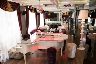 a living room with a white piano in a room at Harmony Palace in Sunny Beach