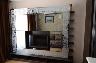 a living room with a tv and a mirror at Harmony Palace in Sunny Beach