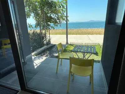 a patio with a table and chairs and the ocean at Aliara Dilara Beach Apartments in Pomorie