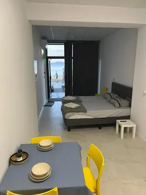 a bedroom with a bed and a table and chairs at Aliara Dilara Beach Apartments in Pomorie