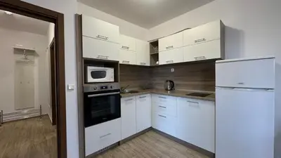 a kitchen with white cabinets and a white refrigerator at Bratanov Cascadas Ravda in Ravda