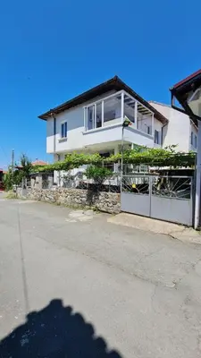 a white house with a fence in front of it at S Apartment in Tsarevo