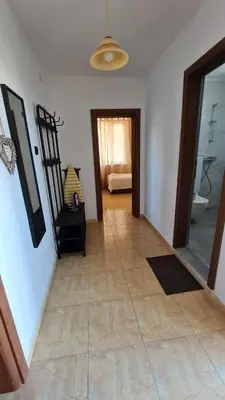 a room with a hallway with a chair and a mirror at S Apartment in Tsarevo