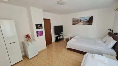 a bedroom with a bed and a television in it at S Apartment in Tsarevo
