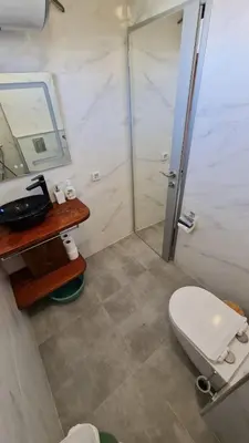 a bathroom with a toilet and a sink and a mirror at S Apartment in Tsarevo