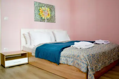 a bedroom with a bed with a blue blanket and a table at Top Location !!FREE parking!! 