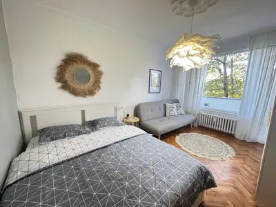 a bedroom with a bed and a chair and a window at LAZUR first line in Burgas City