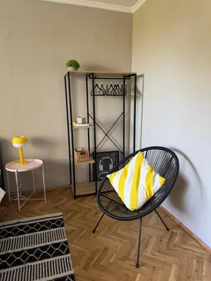 a room with a chair with a yellow and white pillow at LAZUR first line in Burgas City