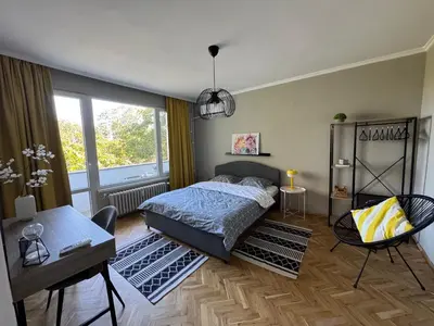 a bedroom with a bed and a table and a window at LAZUR first line in Burgas City