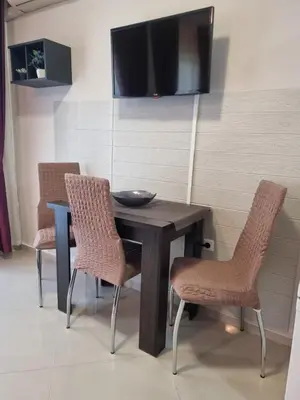 a dining room table with two chairs and a television at Domus Extra Apartment in Sveti Vlas