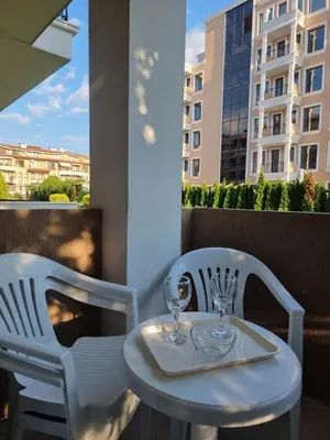 a white table and chairs with glasses on a balcony at Domus Extra Apartment in Sveti Vlas