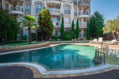 a swimming pool in front of a building at Melia lux apartment in Ravda